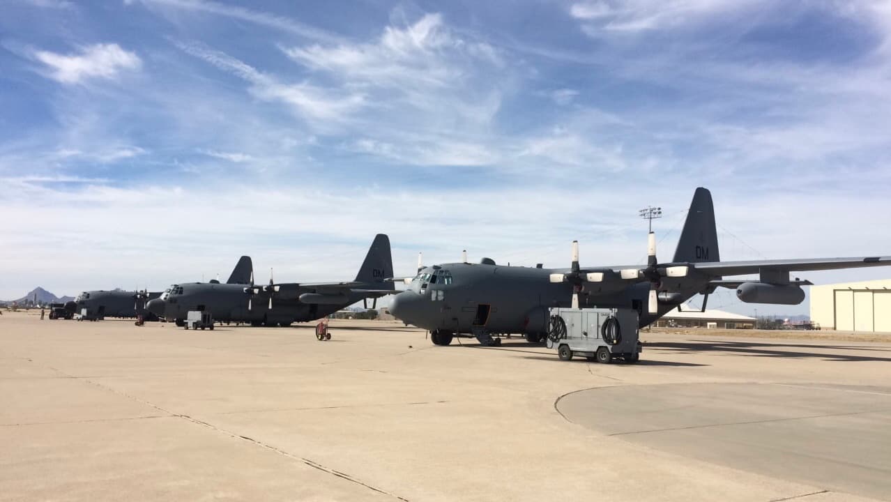 C-130s on a tarmac with blue skies behind them