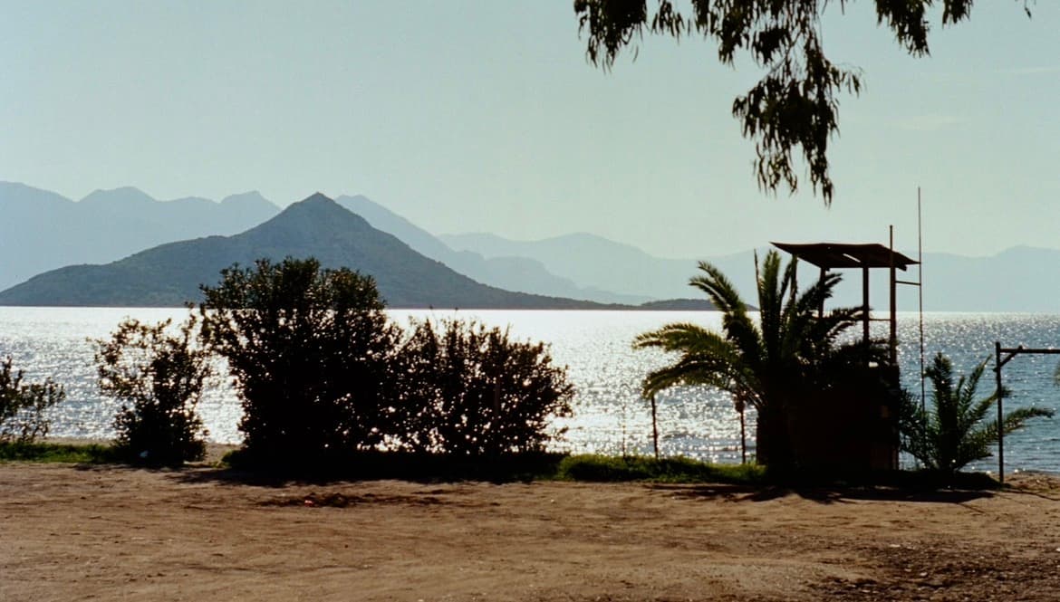 A coastal view of the sea with mountains off in the distance.